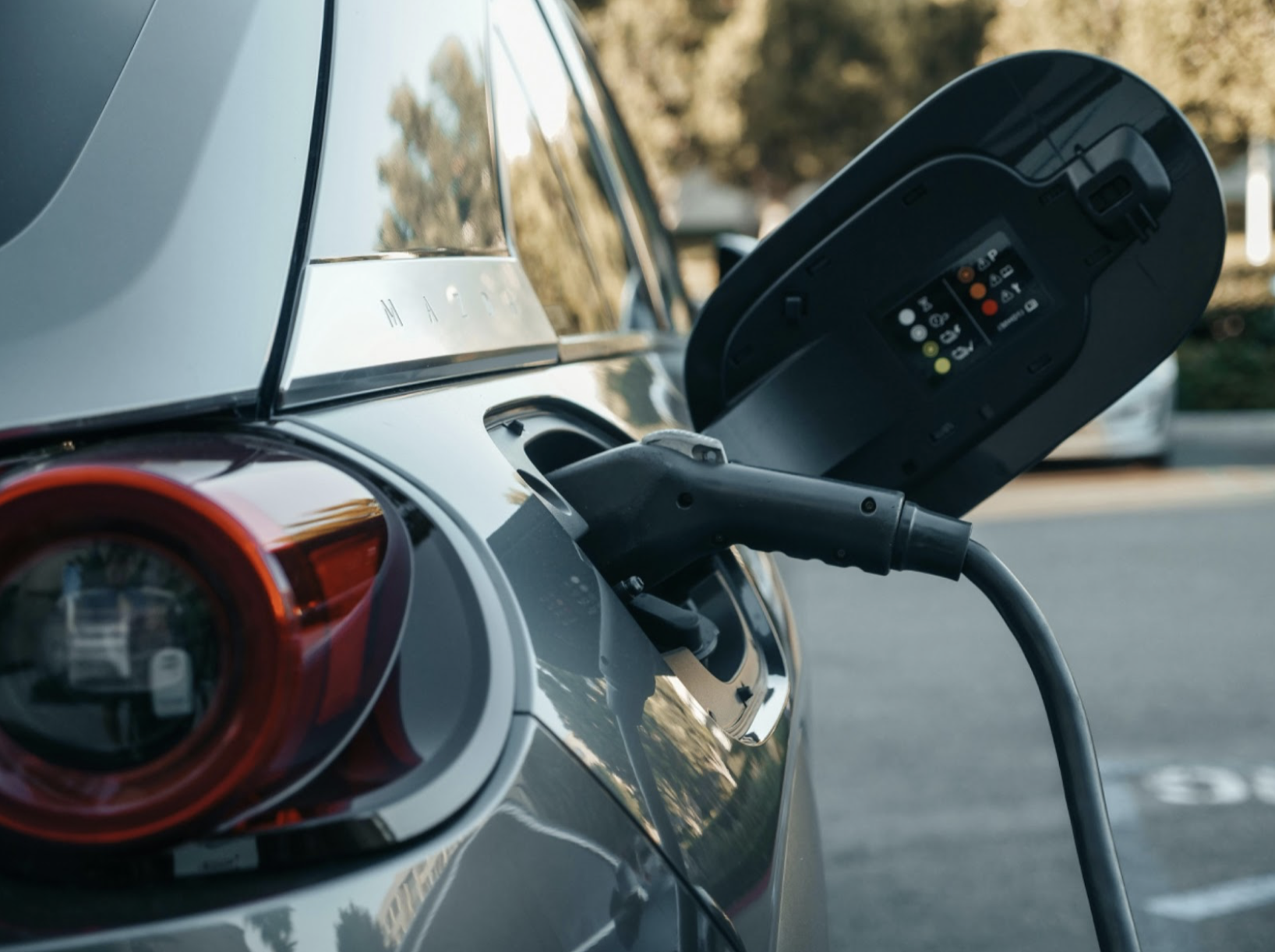 Electric vehicle charging at an outdoor charging station.
